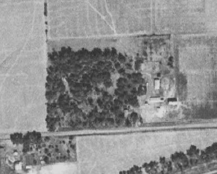 Alt text: Photo from the Iowa DNR Aerial Photography Project. Photo shows the Owl Acres property as it appeared from the air in 1930. The barn which still stands today, casts its shadow near the lower right corner. Five other outbuildings can be seen near the barn, and three of them cast tiny shadows. We think one of the little buildings was the milk house.